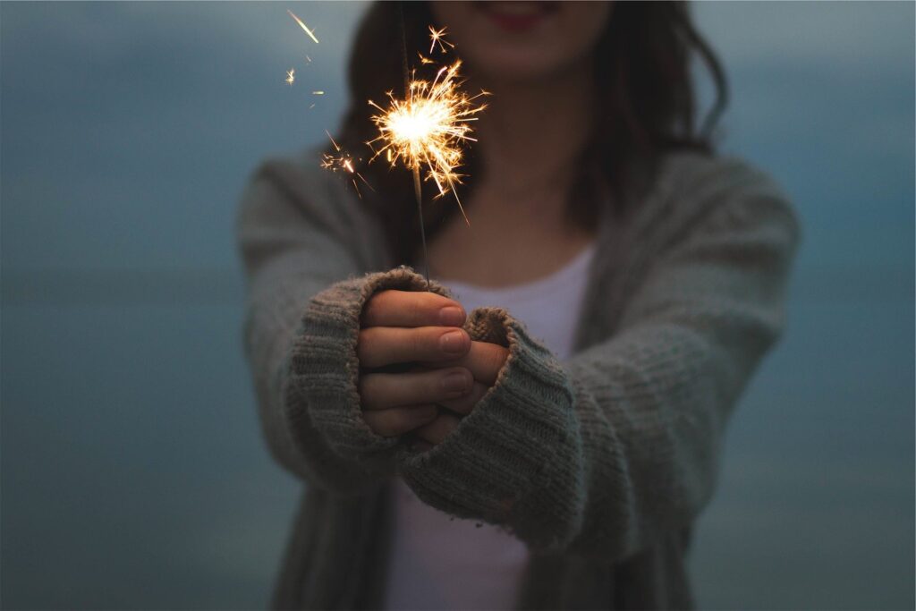 woman holding sparkle ready to achieve goals for the year