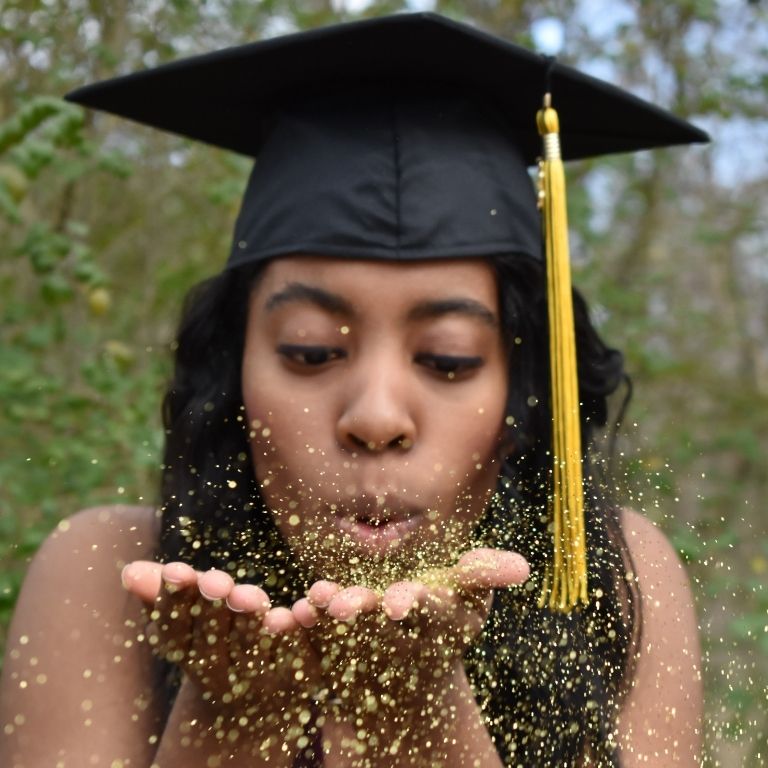 Woman just graduated blowing glitters to celebrate the achievement of a goal Photo by Marleena Garris on Unsplash
