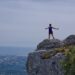 Reach mountains when you start taking responsibility for your life. The image shows a woman happily reaching the top of a mountain. Photo by Amelie & Niklas Ohlrogge on Unsplash