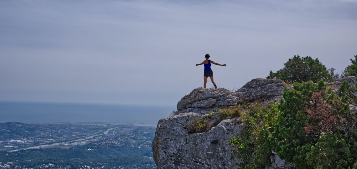 Reach mountains when you start taking responsibility for your life. The image shows a woman happily reaching the top of a mountain. Photo by Amelie & Niklas Ohlrogge on Unsplash