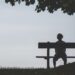 A person sitting in a bench feeling lonely looking for ways on how to overcome this feeling