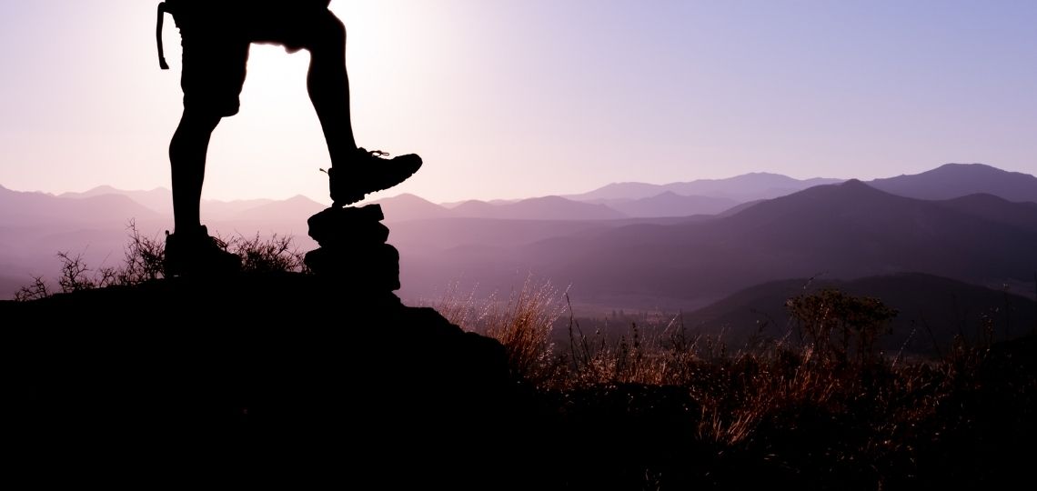 A man in top of a mountain enjoying the process