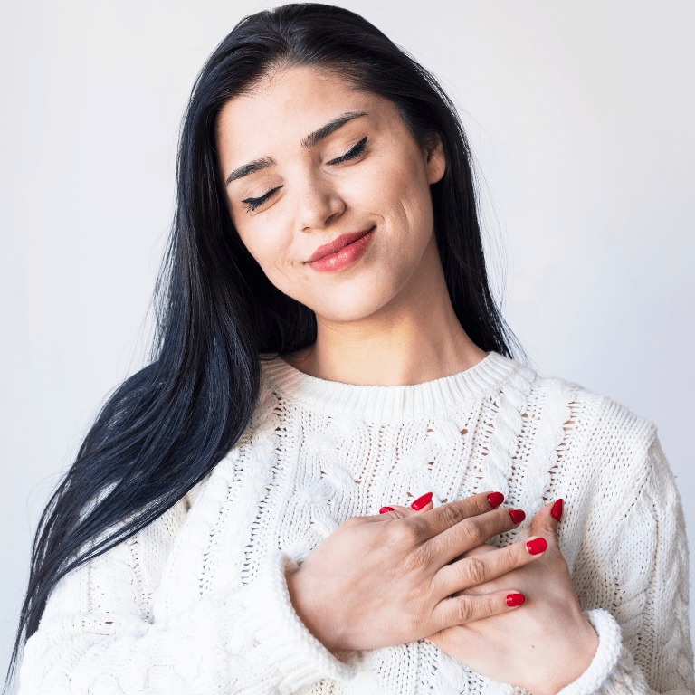 A woman in white sweater who is happy because she is practicing self-love